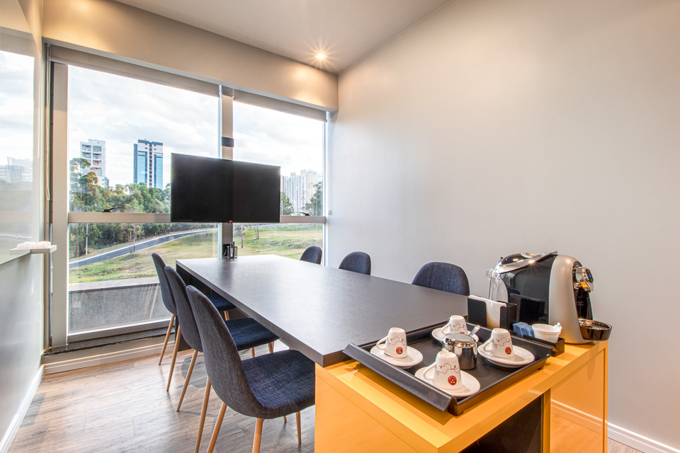 Sala de reunião íntima com TV e café